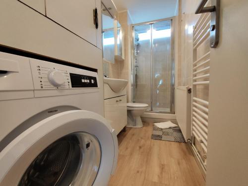 una lavadora en un baño con inodoro en Terre-Mer, en Fort-Mahon-Plage