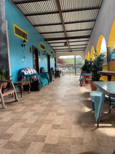 una stanza con tavoli e sedie e una stanza con pareti blu di Hostal Siero a Moyogalpa
