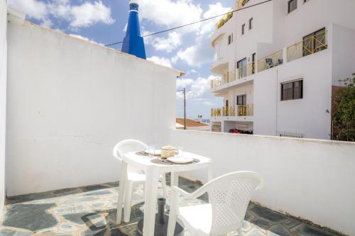 a white table and chairs on the balcony of a building at C14 - Casa da Luz in Luz