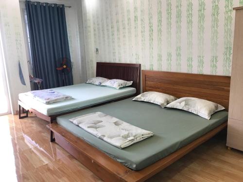 two beds sitting next to each other in a room at Thủ Đức home in Ho Chi Minh City