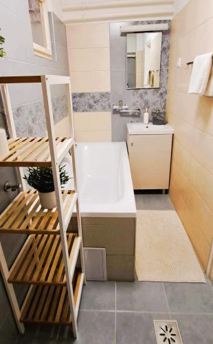 a bathroom with a bath tub and a sink at Indira Vendégház in Nyíregyháza