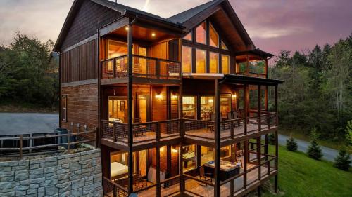 a house on the water with large windows at Smoky Horizon by AvantStay Game Room Movie Theater Deck w Hot Tub Views in Sevierville