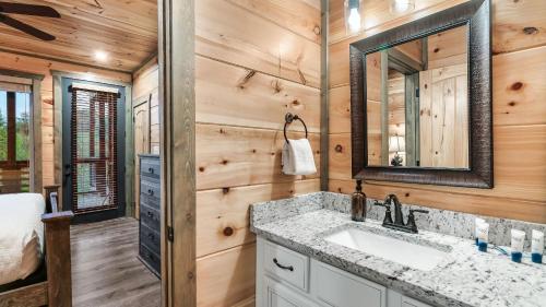 a bathroom with a sink and a mirror at Smoky Horizon by AvantStay Game Room Movie Theater Deck w Hot Tub Views in Sevierville