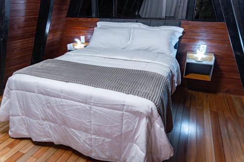 a bedroom with a large bed with two night stands at Retiro Empíreo in Nova Petrópolis