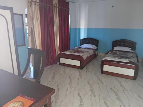 two beds in a room with blue walls at Hotel ratna priya pvt ltd in Biratnagar