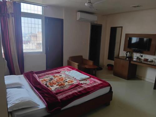 a bedroom with a bed and a tv and a window at Hotel ratna priya pvt ltd in Biratnagar