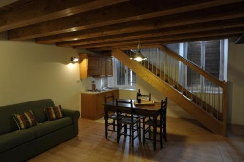 ein Wohnzimmer mit Tisch und Stühlen und einer Treppe in der Unterkunft Agriturismo Giorgio Colutta in Manzano