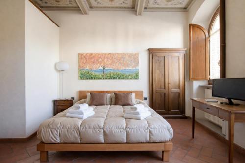 a bedroom with a bed and a desk and a television at La Corte Del Re Suite & Rooms Arezzo in Arezzo