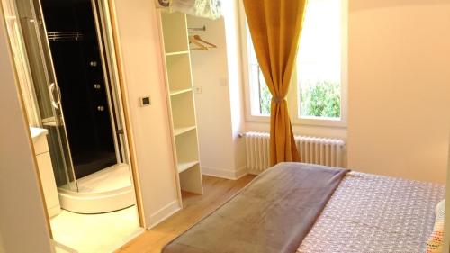 a bedroom with a shower and a bed and a window at Le gÎte du mazagran in Leffincourt