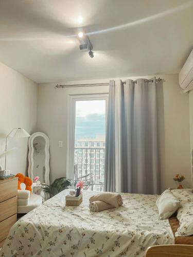 a bedroom with a bed and a large window at Condo at 16th Floor Free Pool Access with Private Balcony in Suba
