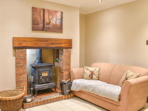 a living room with a couch and a wood stove at Stonebank Cottage - Uk35686 in Hunwick