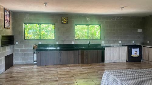 a large kitchen with a sink and two windows at Recanto Colina in Picada Cafe