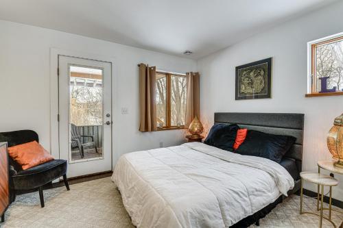 a bedroom with a bed and a chair and a window at Couple’s Retreat Near UVM! Unique Studio w/ Deck in Burlington