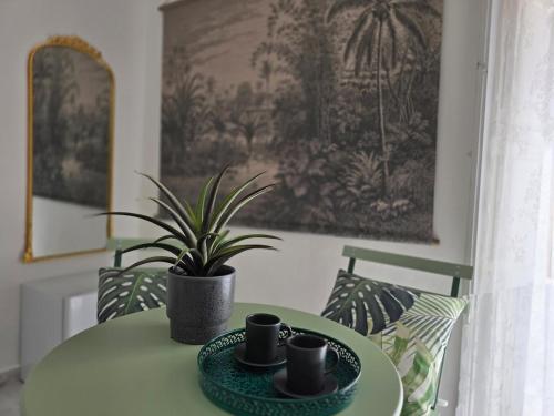a table with two cups and a potted plant on it at La suite a pochi passi dal mare in Trapani