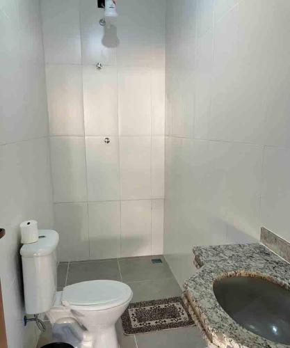 a bathroom with a toilet and a large tub at Recanto da Caluninha in Esmeraldas