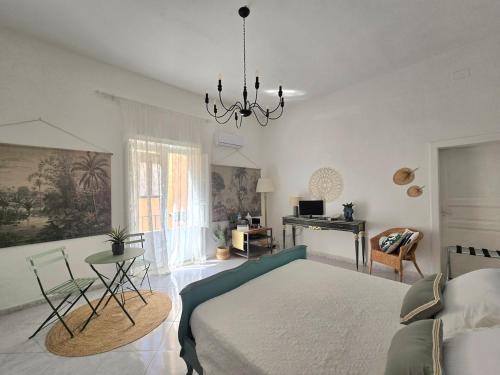 a bedroom with a bed and a table and a desk at La suite a pochi passi dal mare in Trapani