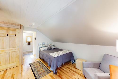 a bedroom with a bed and a couch at Half-Mile to Crystal Lake! Couples Retreat w/ Deck in Beulah