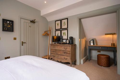 a bedroom with a bed and a desk with a television at The Bottle & Glass Inn - Garden View - Room 1 in Henley on Thames