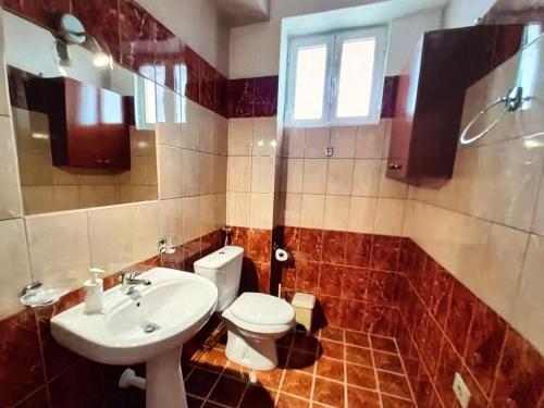 a bathroom with a white toilet and a sink at Sea View in Dhermi in Gjilek