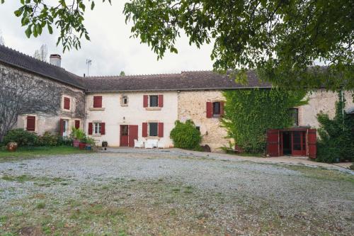 une vieille maison en pierre avec des portes rouges et du lierre dans l'établissement Lorette, à Le Veurdre