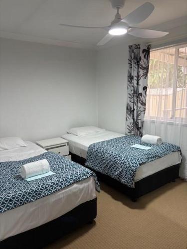 ein Schlafzimmer mit zwei Betten und einem Deckenventilator in der Unterkunft Oxley's Rest in Harrington