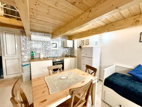 a kitchen and dining room with a table and a bed at Perla 19 - UN LETTO IDEALE in Gaeta
