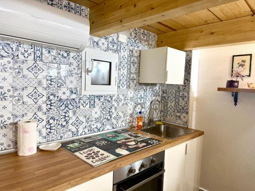 a kitchen with blue and white wallpaper and a sink at Perla 19 - UN LETTO IDEALE in Gaeta