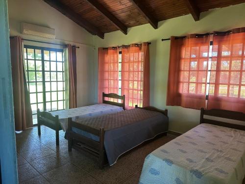 a bedroom with two beds and two windows at Las Dalias in Tacuarembó
