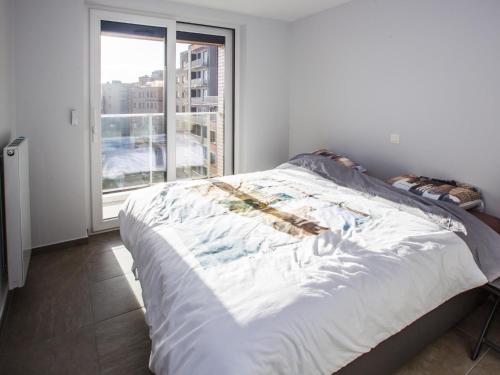 a bed in a room with a large window at Les Amiraux - 0701 + box 2 in Westende-Bad