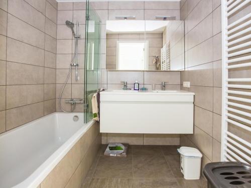 a bathroom with a sink and a bath tub at Les Amiraux - 0701 + box 2 in Westende-Bad