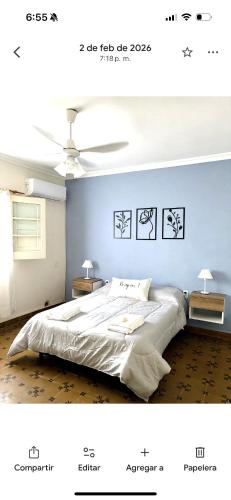 a bedroom with a white bed and a blue wall at Lo de Mingo in San Pedro