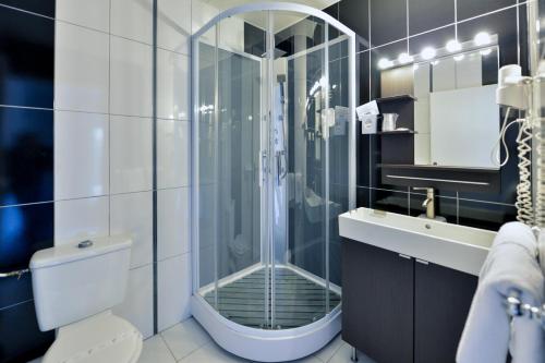 a bathroom with a shower and a toilet and a sink at Contact Hotel Le Moulin Neuf Chantonnay in Chantonnay