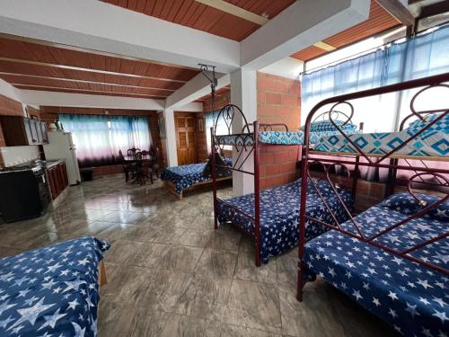 a room with two bunk beds and a kitchen at Hotel Montañitas in Guatapé