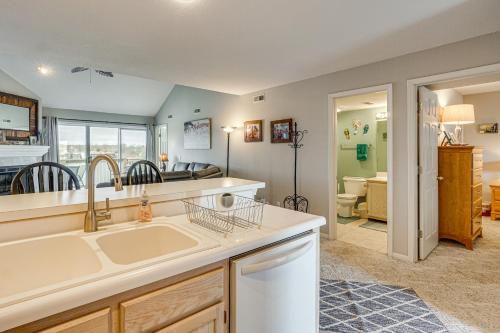 a kitchen with a sink and a living room at Pool & Beach Access: Lake of the Ozarks Condo in Osage Beach