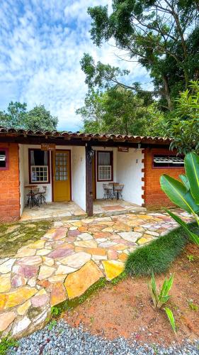 a house with a patio with tables and chairs at POUSADA PARLATORIUM in Tiradentes