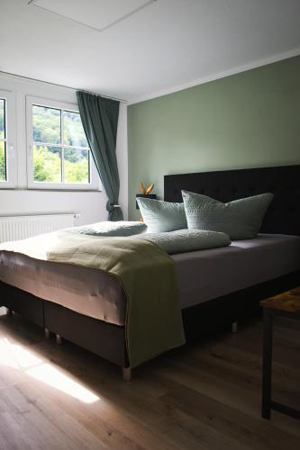 a large bed in a bedroom with a window at Landhaus Sonnenwinkel in Brodenbach
