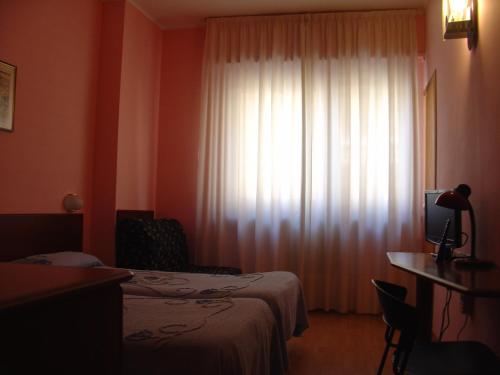 a hotel room with two beds and a window at Domus Hotel in Alessandria