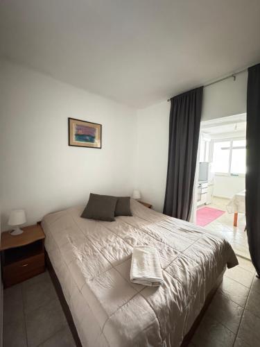 a bedroom with a large bed and a window at Apartment Anka Polače in Polače