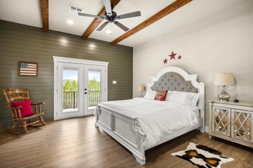a bedroom with a white bed and a ceiling fan at NEW Stunning Views & Lake Access Villa in Granbury