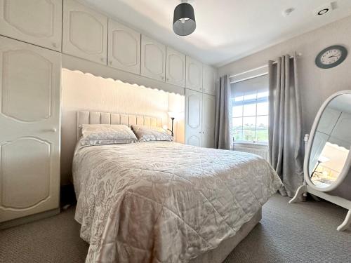 a bedroom with a large white bed and a large window at Ma Monaghan's Cosy Cottage County Tyrone in Pomeroy