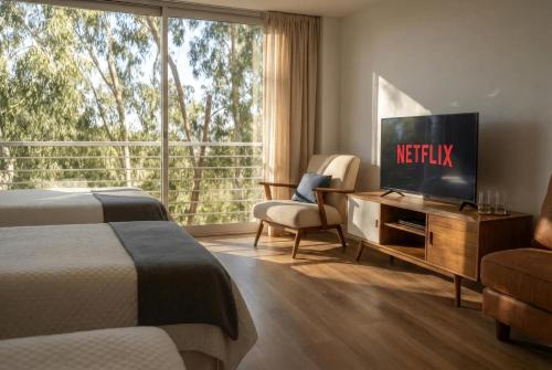 a hotel room with a television and a couch and a chair at iDeal Concord Pilar Aparts in Pilar