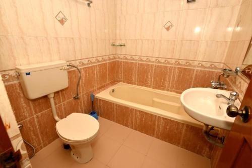 a bathroom with a toilet and a sink and a tub at Scandi-Stay 2BR by Benaulim Beach in Benaulim