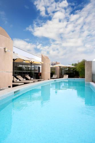 a large swimming pool with blue water in front of a building at Jose Antonio Deluxe in Lima