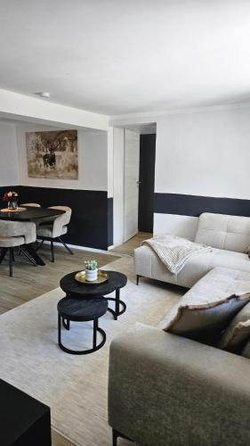 a living room with a couch and a table at Sauerland Apartments in Schwalefeld