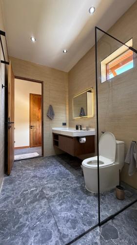a bathroom with a tub and a toilet and a sink at Private Pool Villa in Khao Lak