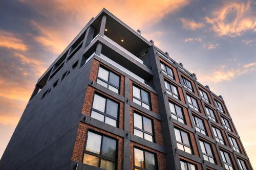 a tall black building with a sunset in the background at Dutch Hotel Long Island City New York , Belvilla District 6 Formerly Sonder in Long Island City