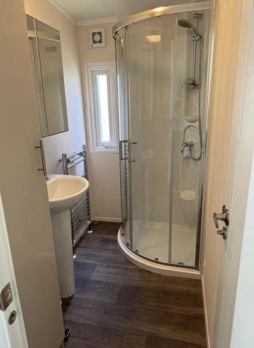 a bathroom with a shower and a sink at Vakantiehuisje op 5 star kindercamping in Mariënberg