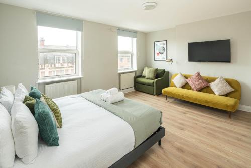 a bedroom with a large bed and a couch at Huge Modern 3 Bed Flat Central For Sightseeing in London