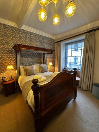 a bedroom with a large bed and a window at The Ancient Gatehouse & Rugantino Restaurant in Wells