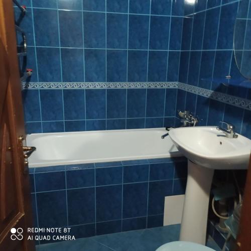a blue tiled bathroom with a tub and a sink at Центр, 2х комнатная студио возле парка, WIFI in Vinnytsya